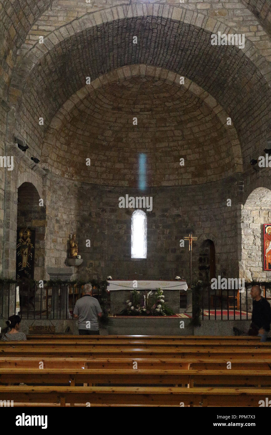 I componenti interni e l'altare di pietra romaneque Maria Santissima chiesa (Iglesia de Santa Maria) durante la celebrazione di una messa in Ainsa, Spagna. Foto Stock