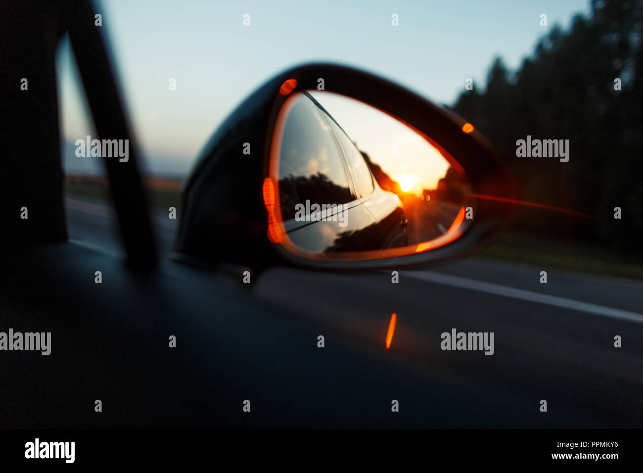 Bel tramonto nello specchio della vettura. Concetto di viaggio Foto Stock