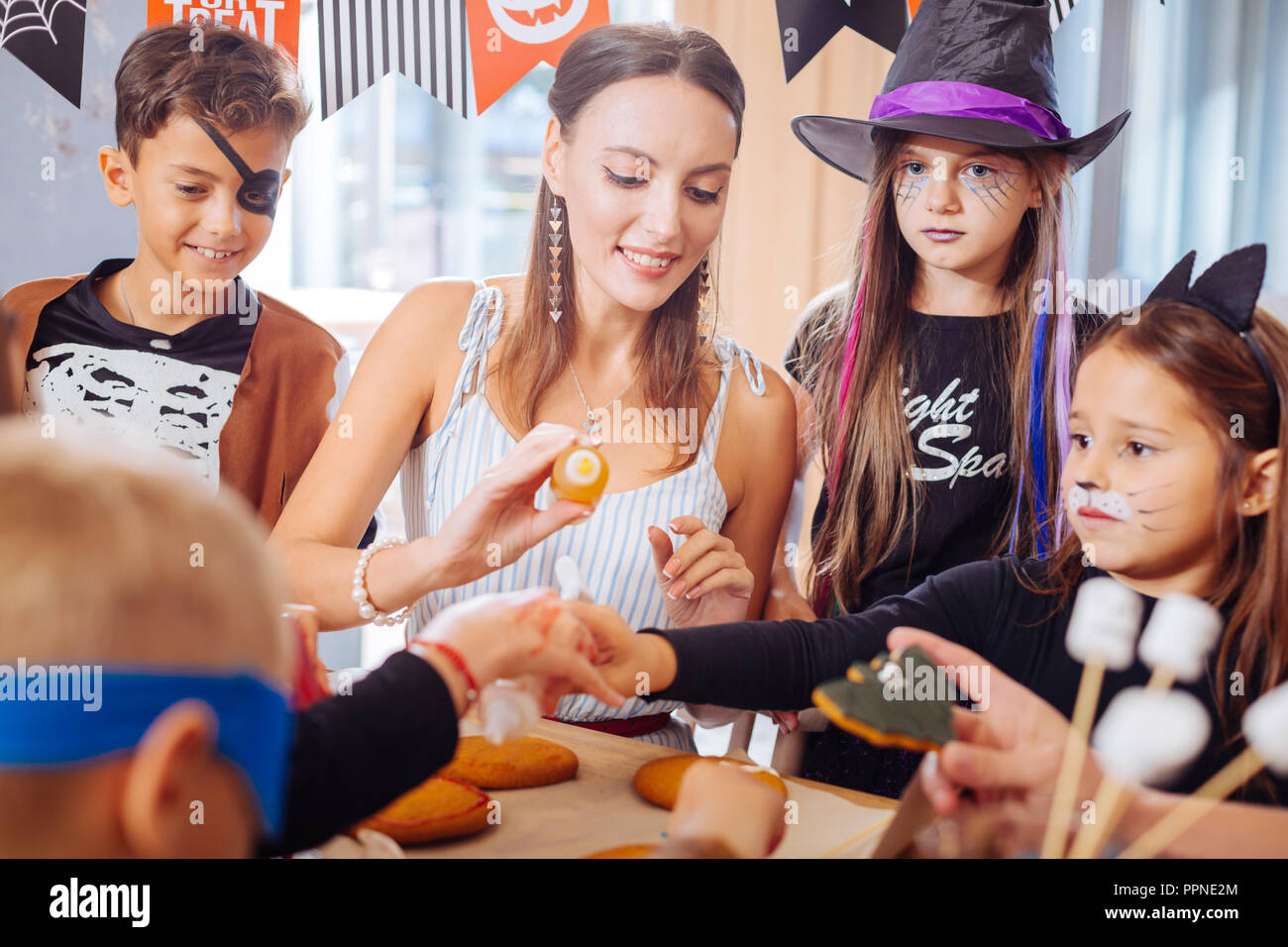 I bambini che indossano costumi di Halloween rendendo dolci per il partito con il maestro Foto Stock