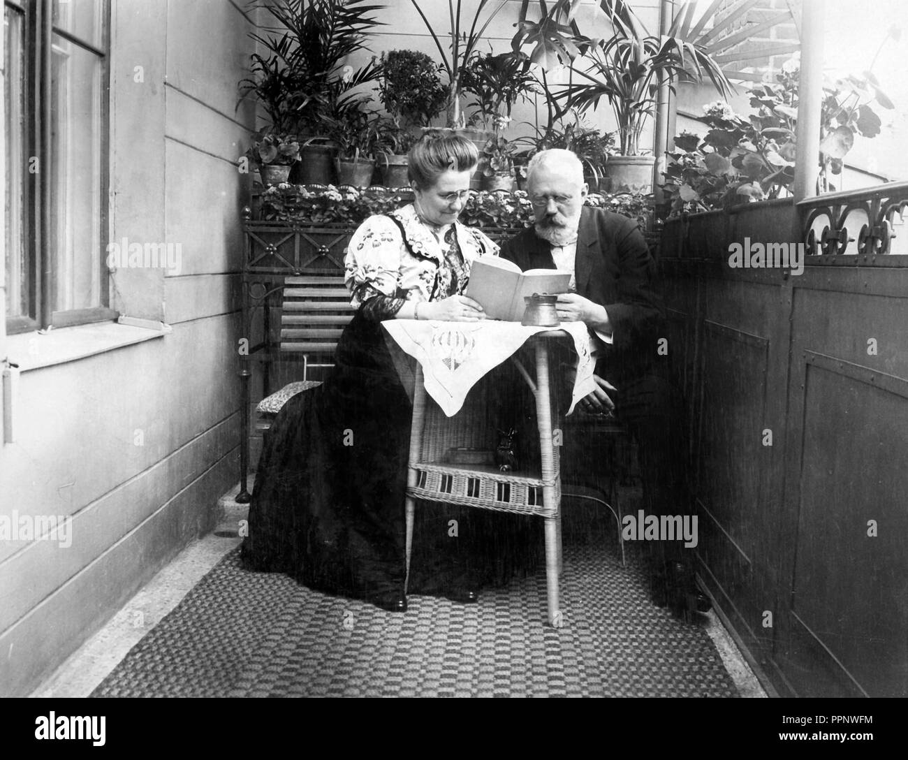 Coppia, coppia senior è seduta sul balcone e la lettura di un libro insieme, 1930, Germania Foto Stock