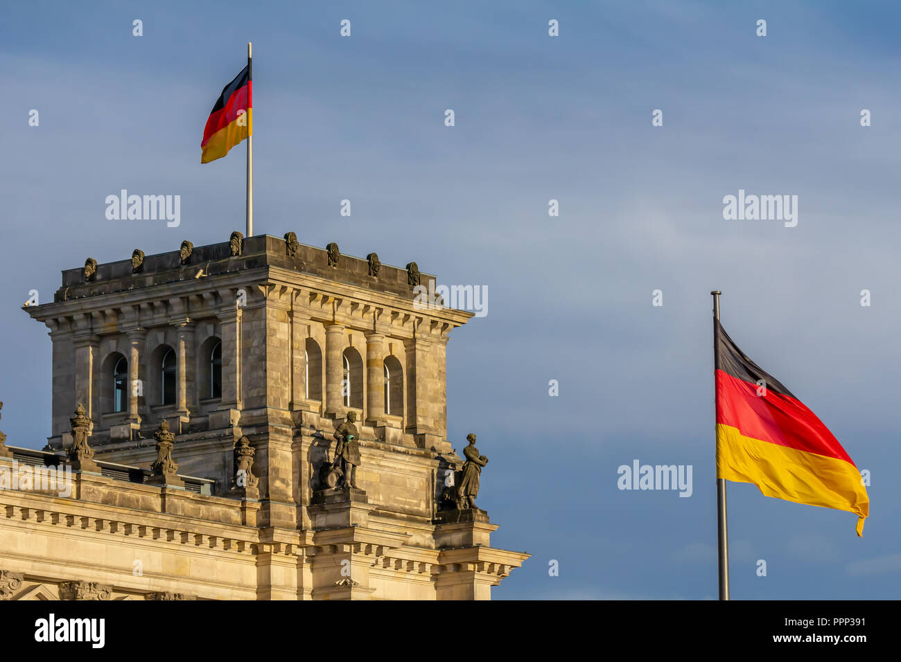 Repubblica federale di Germania, Tedesco bandiera nazionale presso il palazzo del Parlamento sventola sul cielo blu sullo sfondo Foto Stock