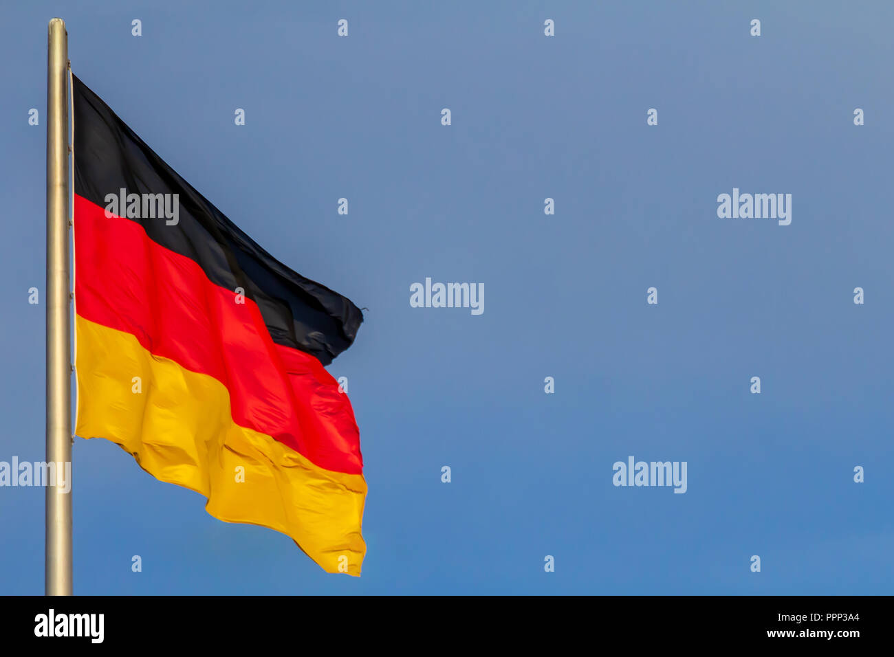 Repubblica federale di Germania, nazionale tedesco di bandiera sventola sul cielo blu sullo sfondo Foto Stock