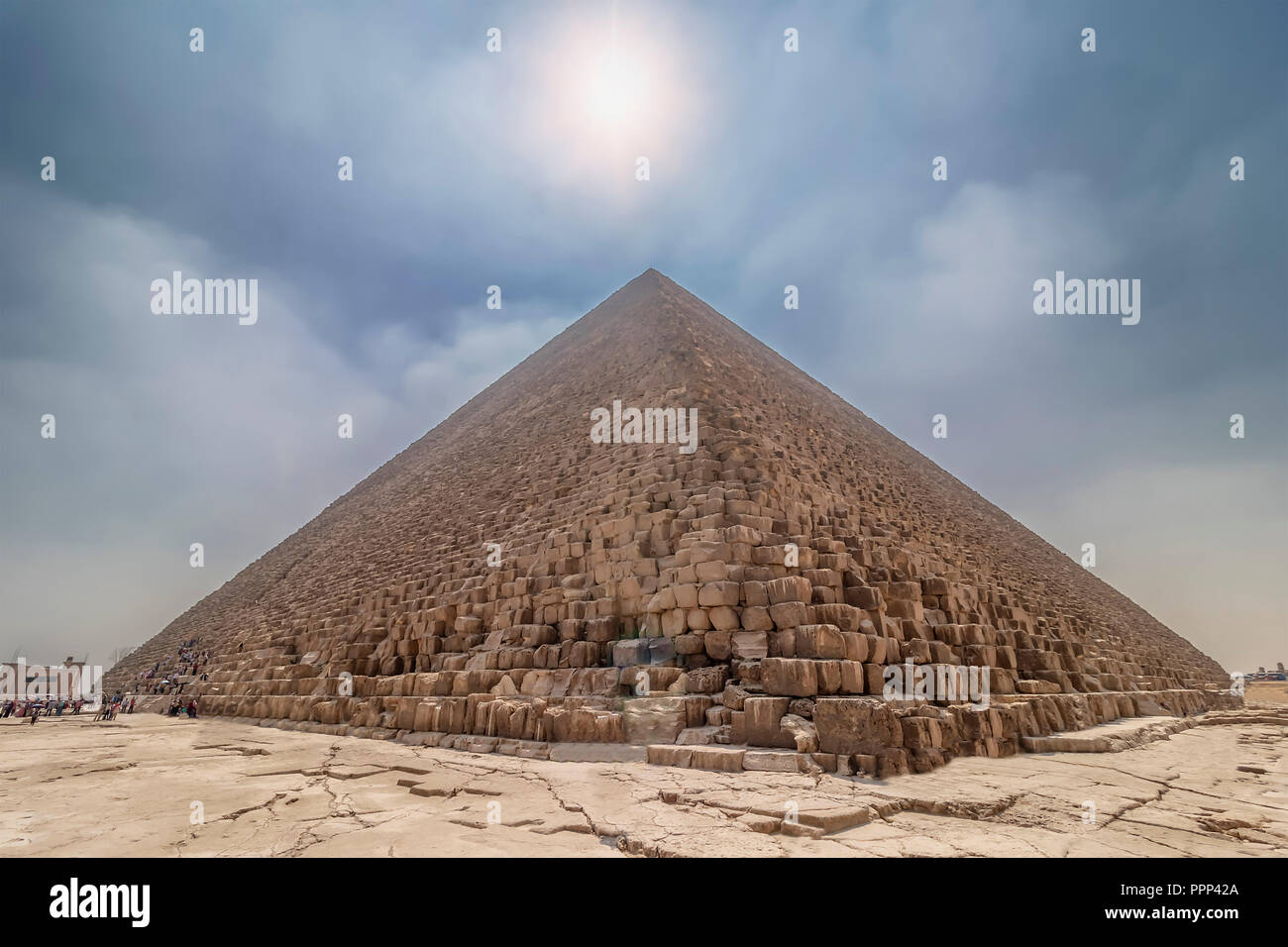 La Piramide di Cheope illuminata dal sole di retroilluminazione, con persone che entrano all'interno per visitare. La zona con le grandi piramidi di Giza in Egitto Foto Stock