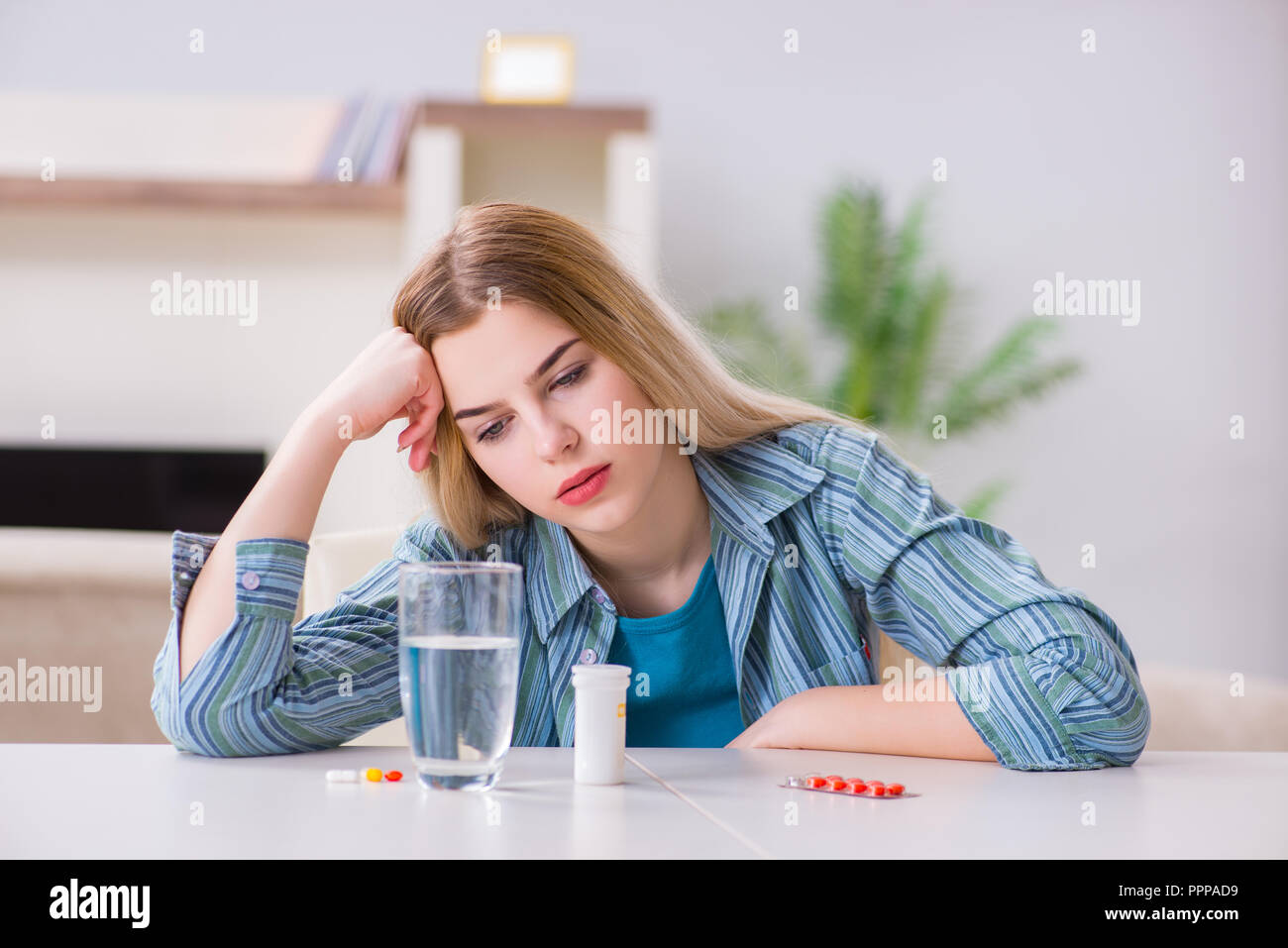 Donna di prendere le pillole per affrontare il dolore Foto Stock