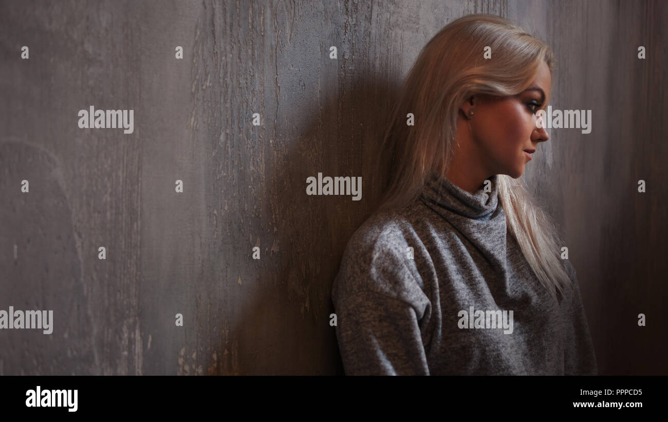 Premuto donna. ragazza bionda seduta sul pavimento, la tristezza e la depressione, la nozione di problema psicologico Foto Stock