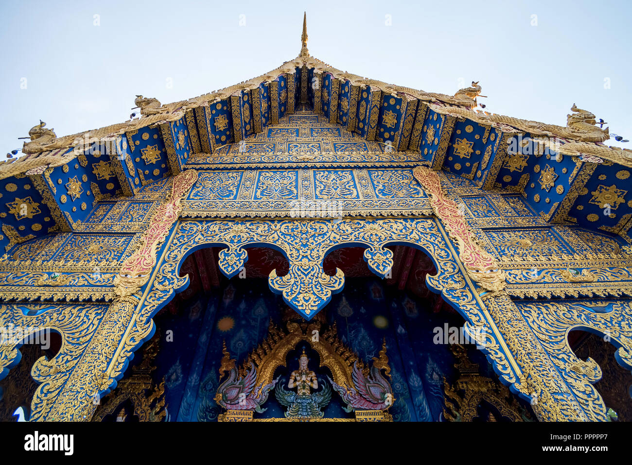 Colorato esterno ornamentale di Wat Rong Suea dieci (noto anche come Tempio Azzurro) con un bel design contro il cielo blu, Chiang Rai Foto Stock