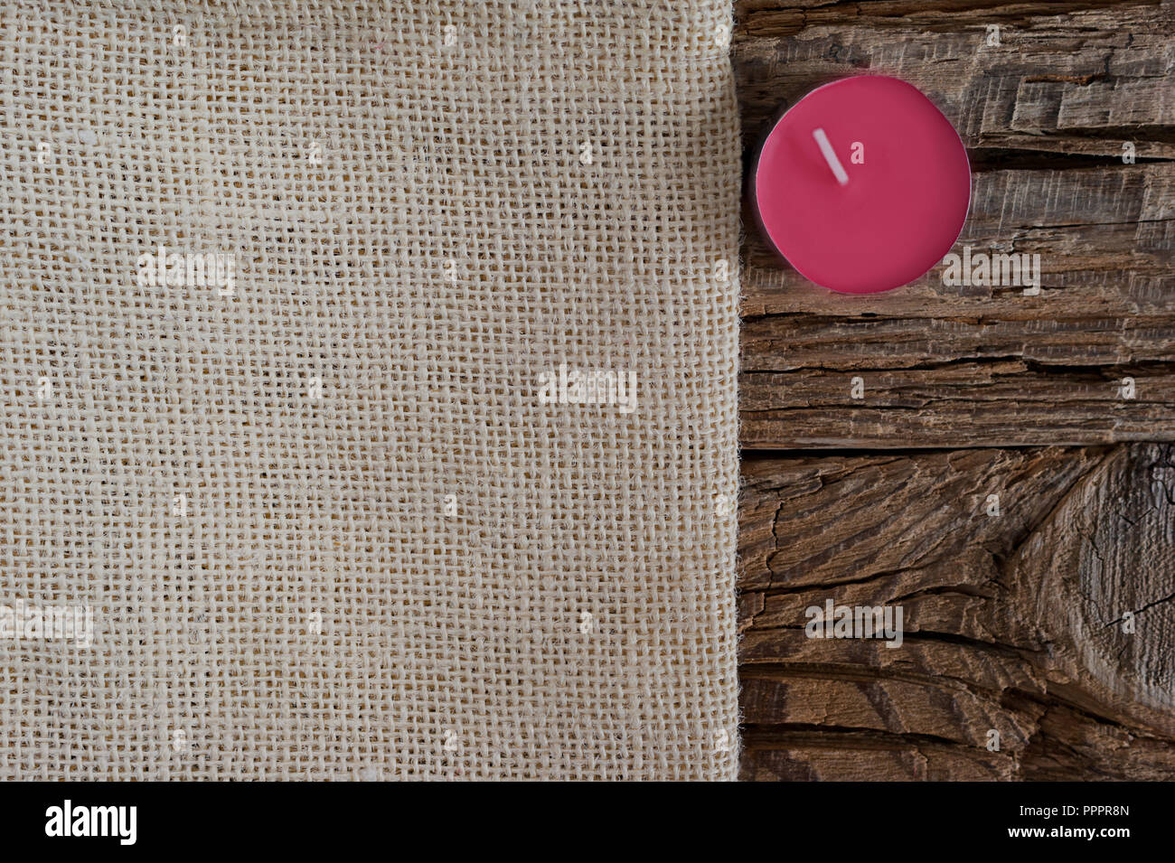 Stagione di biglietto di auguri concetto di design con copia spazio. Panno beige, un gelso viola candela su una grossa sullo sfondo di legno. Foto Stock