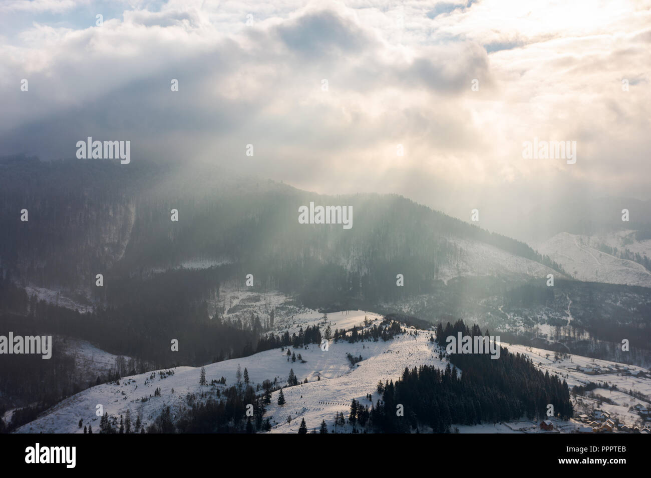 Fasci di luce in inverno mattina. splendida campagna con snowy hill Foto Stock