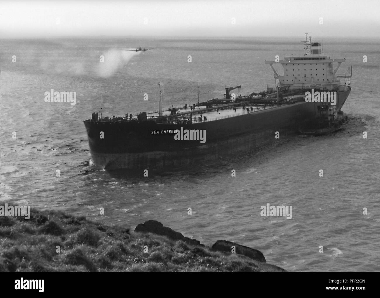 Sea Empress fuoriuscite di olio in entrata per il Milford Haven fluviale in Pembrokeshire, Regno Unito Galles il 15 febbraio 1996 e si è messo a terra dopo aver colpito le rocce. Qui illustrato con un aeromobile con spruzzatura di prodotti chimici per l'operazione di pulizia e disperdere le fuoriuscite di olio. In seguito alla fuoriuscita della Sea Empress è stato riparato e rinominato per cinque volte. In 2004, è stata venduta e si trasferisce a Chittagong come galleggianti di produzione, stoccaggio e offload dell'unità. Nel 2009, è stata acquisita da Oriental Ocean Shipping Holding PTE Ltd, rinominato Welwind MV e convertito al bulk carrier. Nel 2012, venne ribattezzata come vento 3. Foto Stock