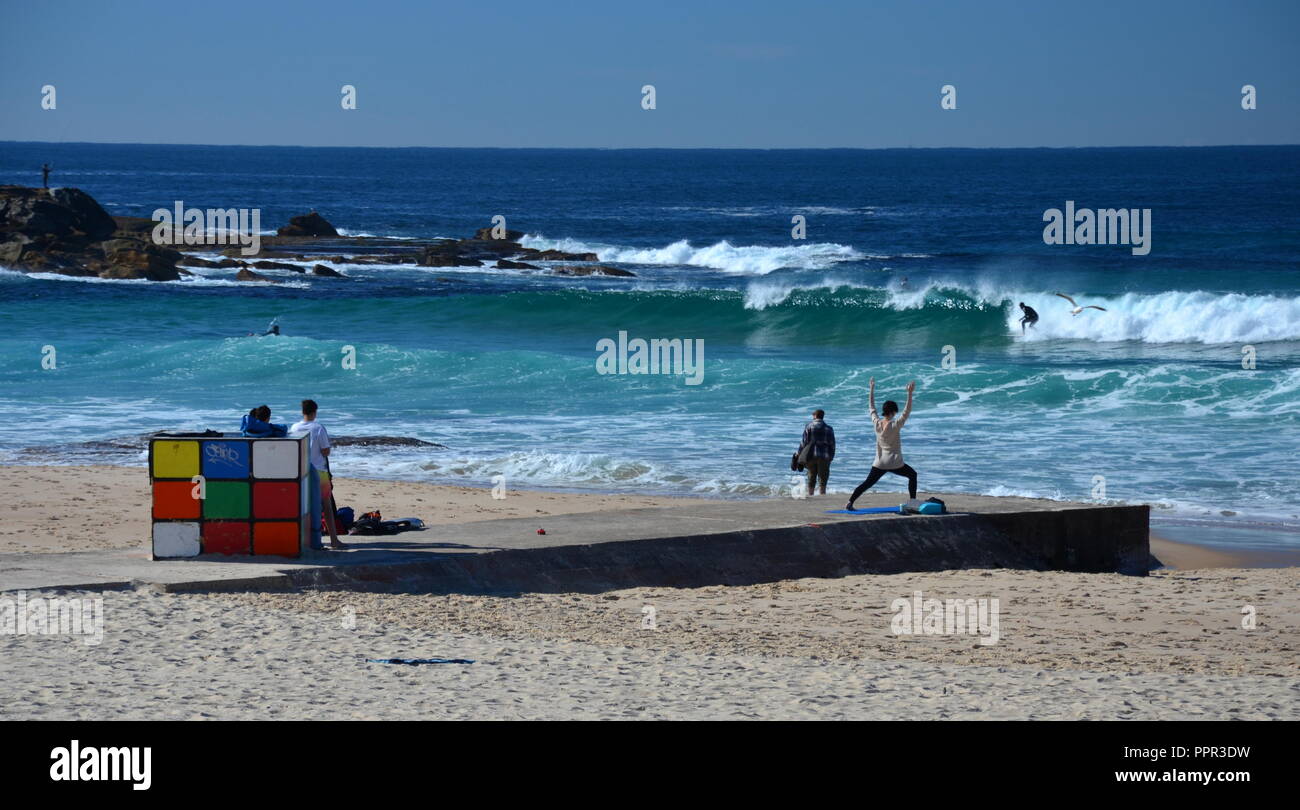 Sydney, Australia - 5 luglio 2015. Rubik Cube si trova sulle rive di Maroubra Beach. Persone per godere del sole e prendere l'esercizio. Foto Stock