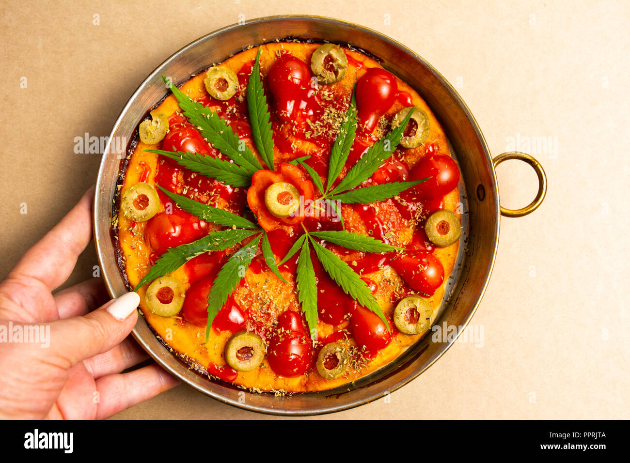 Serve una pizza con la marijuana su un vassoio in primo piano Foto Stock