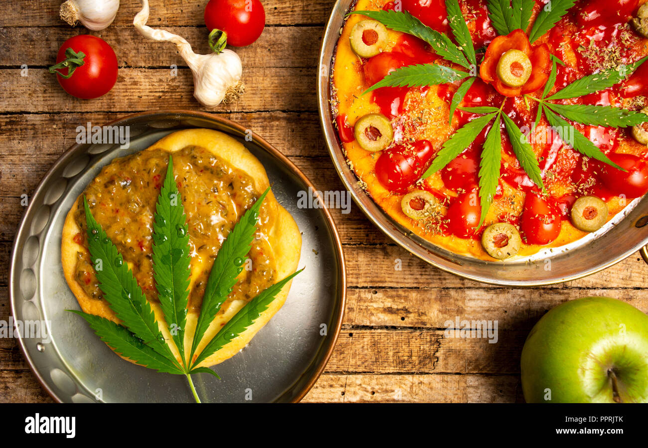 La Pizza e la pasta con la marijuana su un vassoio vista superiore Foto Stock