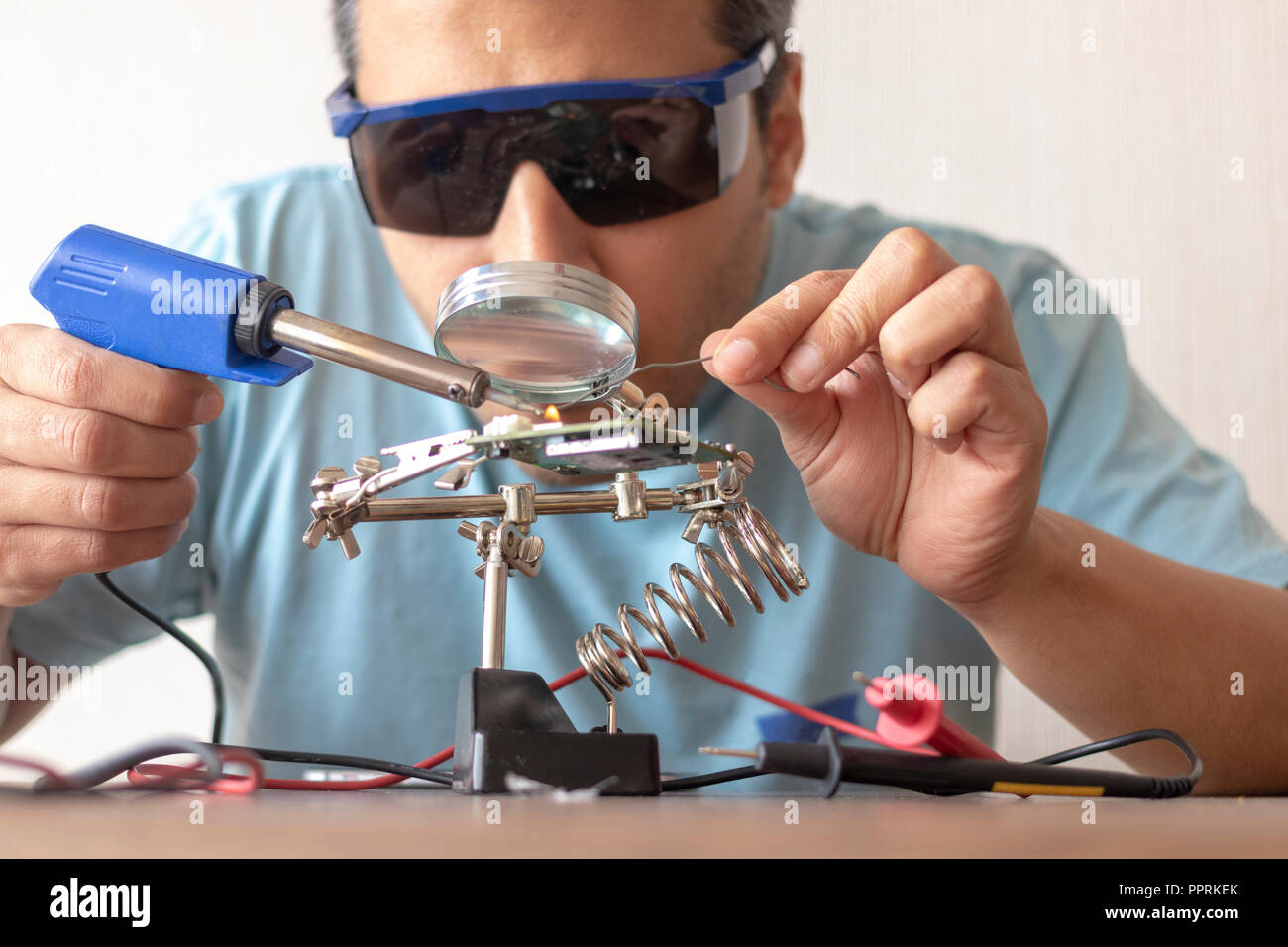 Tecnico elettronico lavorando alla riparazione di una scheda Foto Stock