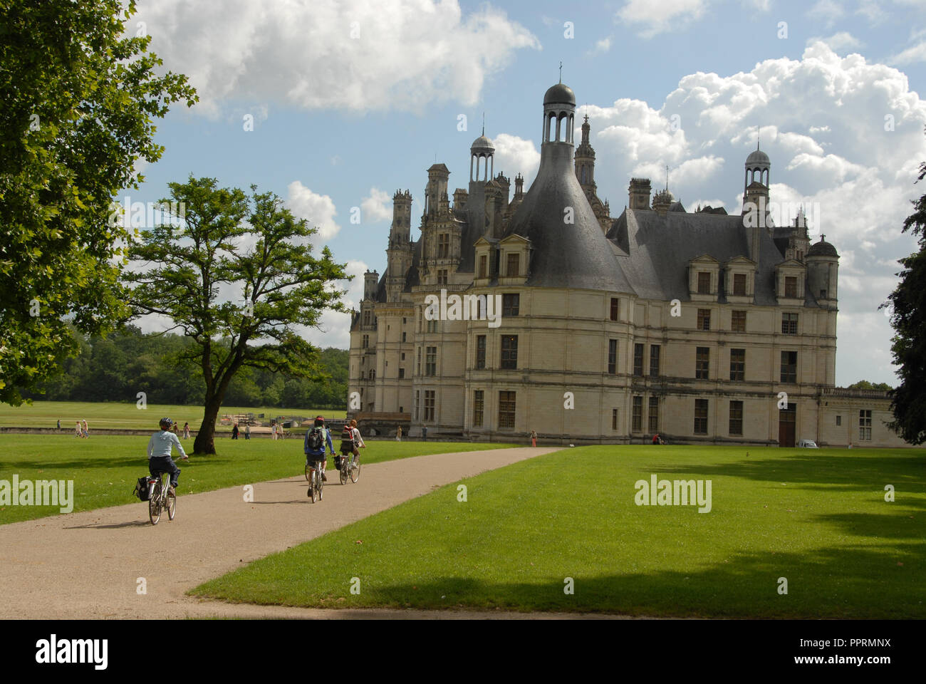 Un gruppo di ciclisti su un tour in bicicletta di arrivare presso il Royal Chateau de Chambord nella Val de Loire (Valle della Loira in Francia. Il castello è uno dei th Foto Stock
