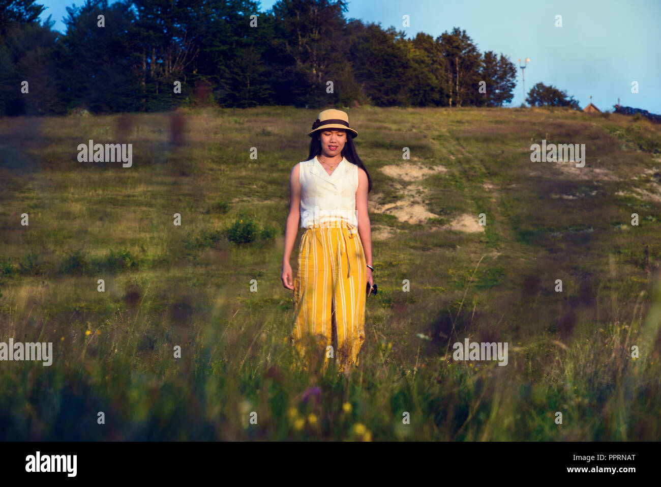 Allegro escursionista a piedi su una montagna al tramonto Foto Stock