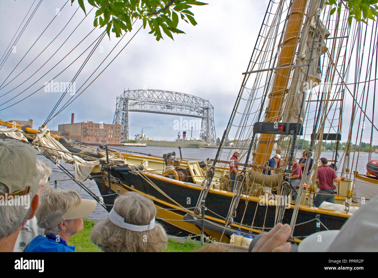 L'orgoglio di Baltimora ormeggiata nel porto di Duluth del Lago Superior come una lunga nave da carico passa sotto la funivia Ponte. Duluth Minnesota MN USA Foto Stock