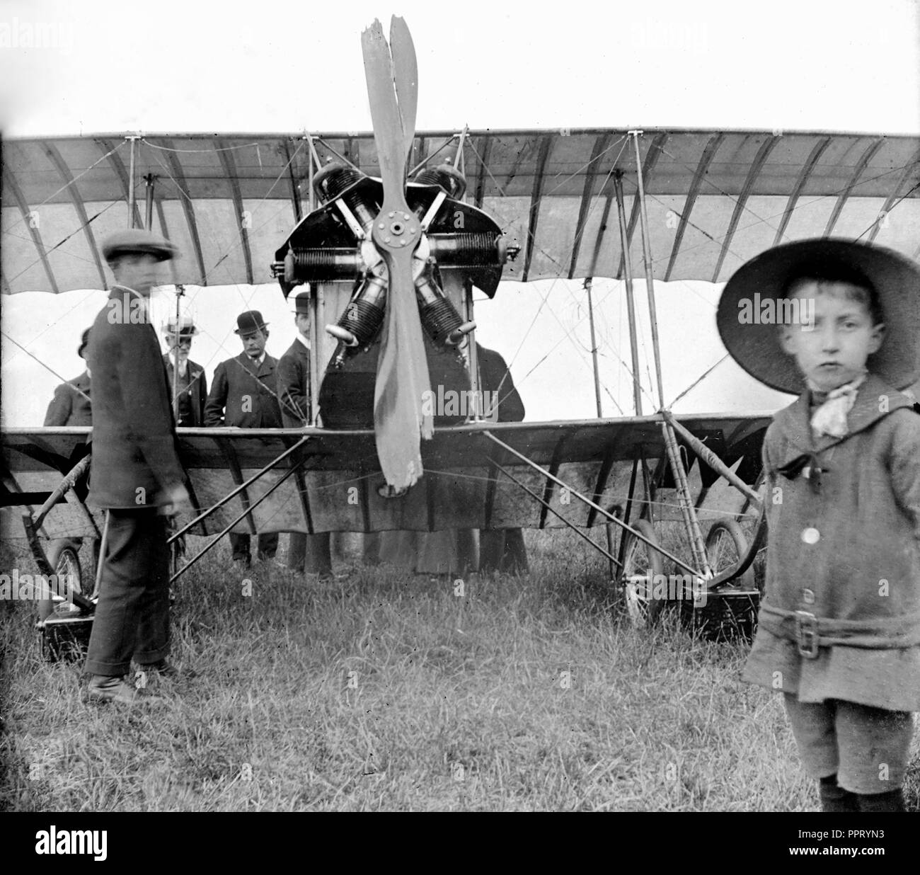 Un gruppo di uomini e ragazzi guardare su un aereo che crash atterrato fuori Londra, ca. 1914. Foto Stock