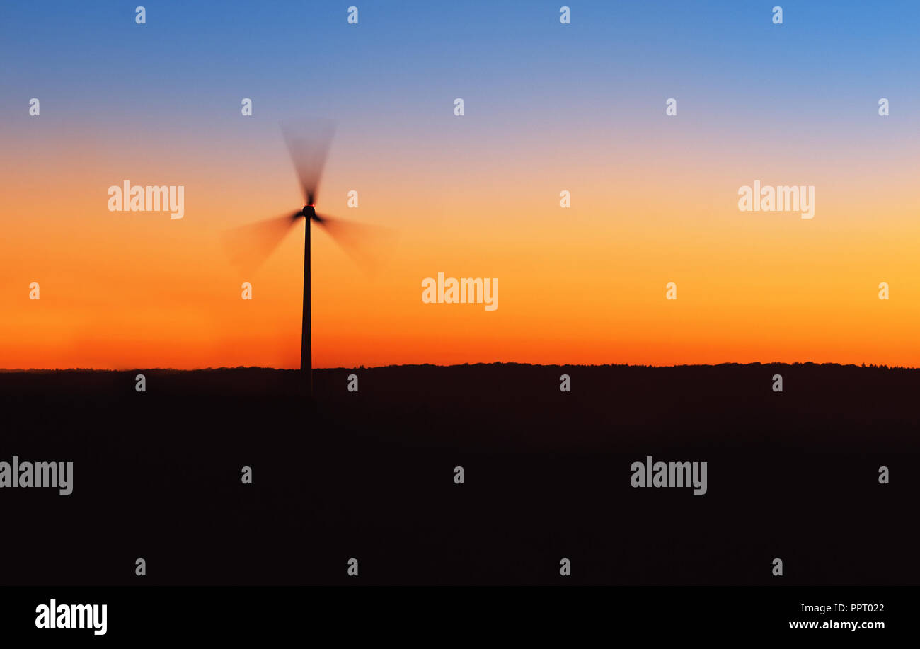 Silhouette di turbina eolica nel tramonto. Foto Stock