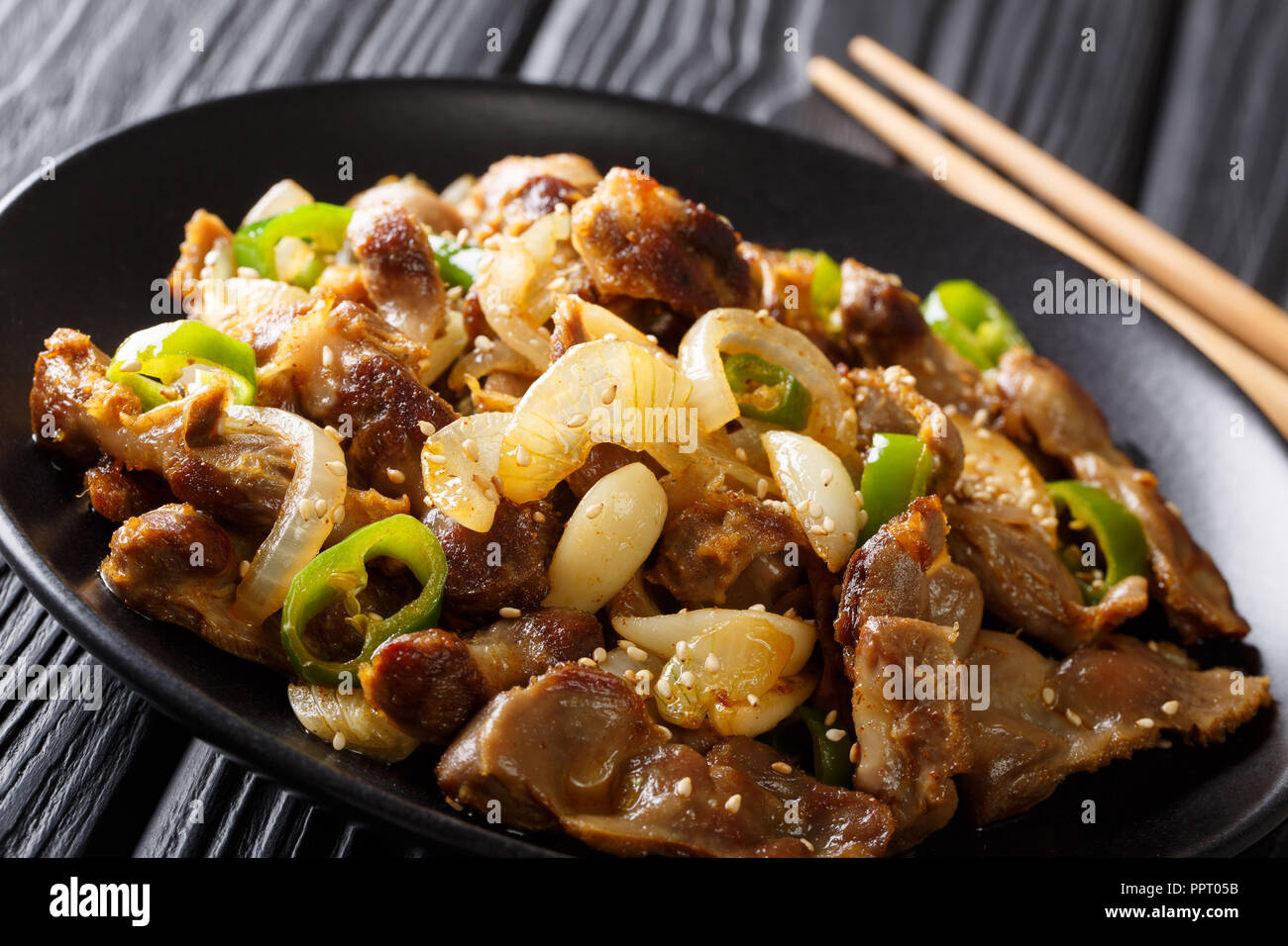 Dak-ttongjip-bokkeum hicken ventriglio con cipolle, aglio, peperoncino e sesamo vicino sul tavolo orizzontale. Foto Stock