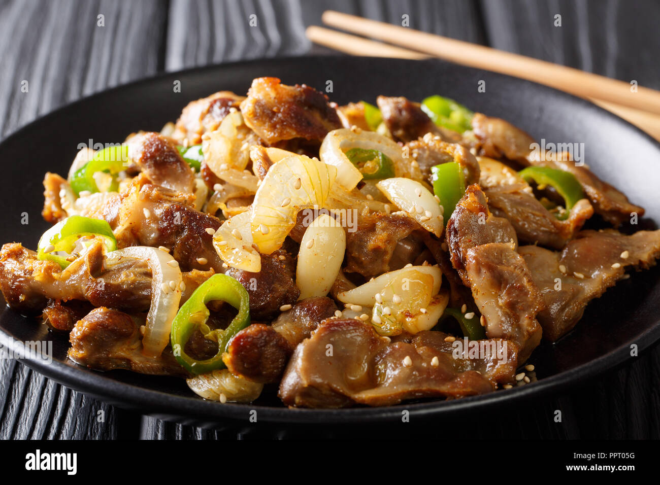 Il ventriglio di pollo STIR FRY - Dak Ddong Jjip è un piatto coreano close-up su una piastra su un piano orizzontale. Foto Stock