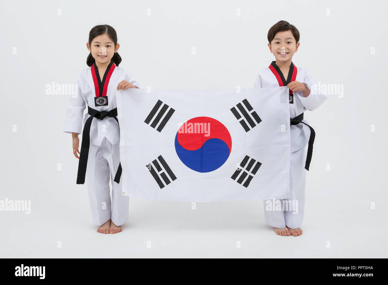 Bambini all'istruzione. Taekwondo, piccolo ragazzo e ragazza pratica le arti marziali in sfondo bianco 254 Foto Stock