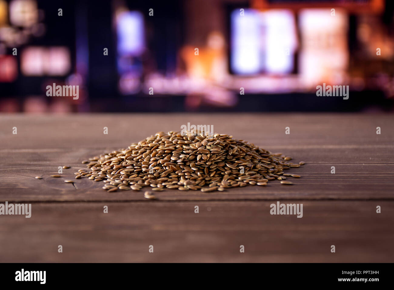 Sacco di fresco intero flaxseeds marrone heap con ristorante in background Foto Stock
