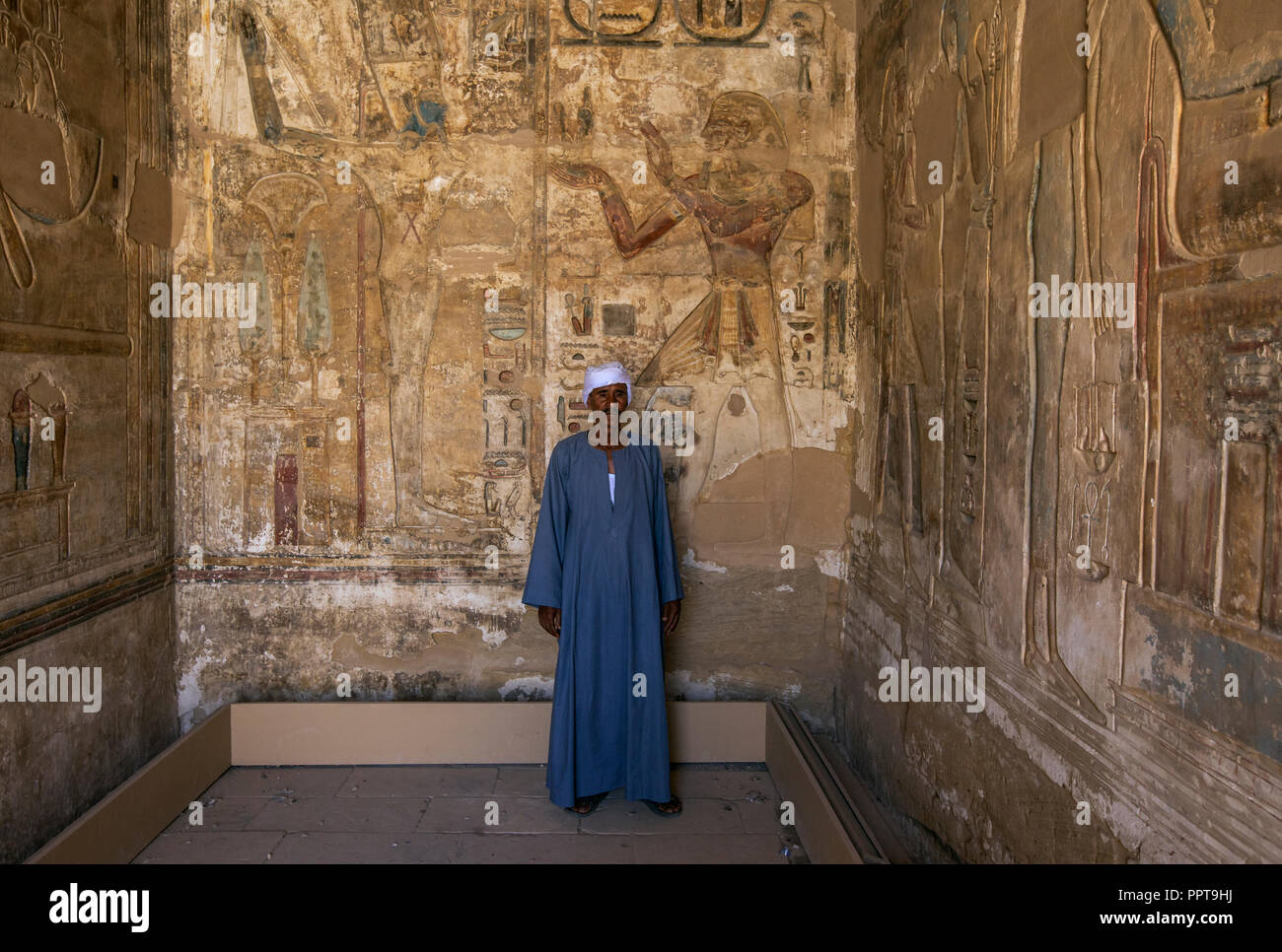Uomo egiziano in piedi all'interno della tomba nel tempio di Ramses III a Medinet Habu a Luxor, Egitto Foto Stock
