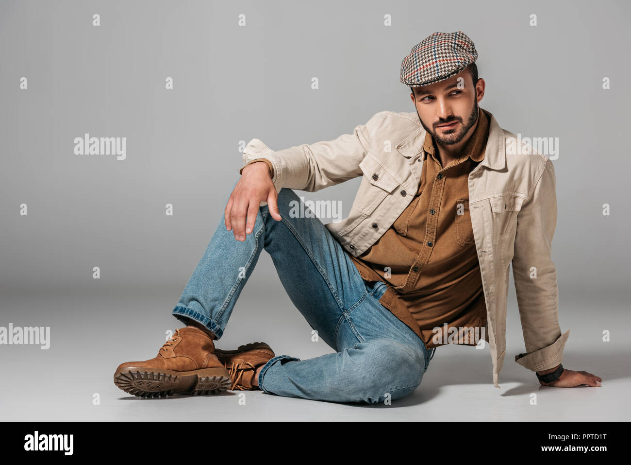 Uomo Barbuto in posa di velluto a coste t-shirt, jeans e autunno giacca di  tweed e cappuccio, su grigio Foto stock - Alamy