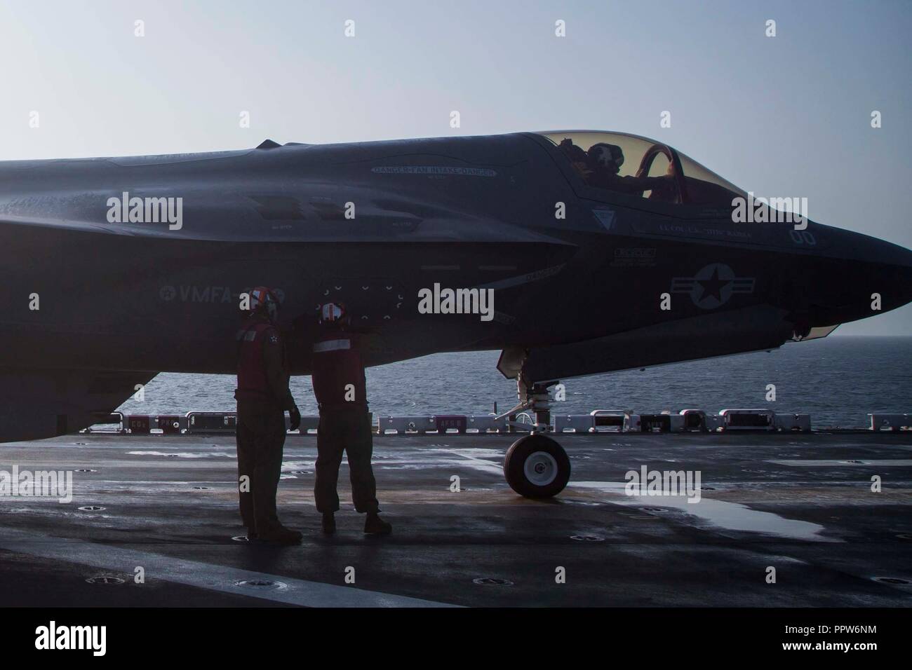 Stati Uniti Quinta Flotta AREA DI OPERAZIONI - STATI UNITI Marines con Marine Fighter Squadron di attacco 211, 13 Marine Expeditionary Unit (MEU), garantire un pannello è sicuro su un F-35B Lightning II in preparazione per la F-35B del primo sciopero di combattimento, Sett. 27, 2018. L'Essex è il fiore all' occhiello per la Essex anfibio gruppo pronto e, con l'avviato XIII MEU, è distribuito negli Stati Uniti Quinta Flotta area di operazioni a sostegno di operazioni navali per garantire stabilità marittimo e la sicurezza nella regione centrale di collegamento del Mediterraneo e del Pacifico attraverso l'Oceano Indiano occidentale e tre strozzatura strategico punto di interesse Foto Stock