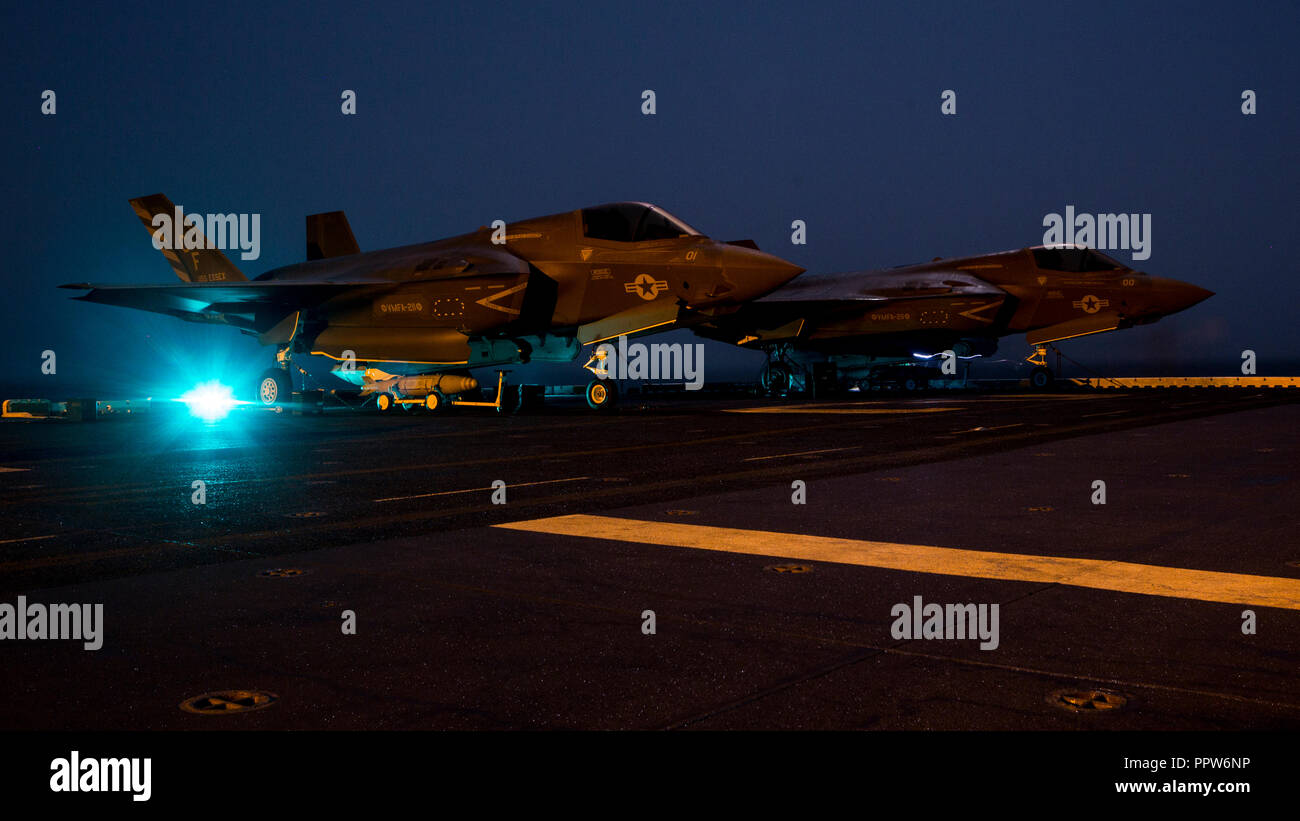 Stati Uniti Quinta Flotta AREA DI OPERAZIONI - STATI UNITI Marines con Marine Fighter Squadron di attacco 211, 13 Marine Expeditionary Unit (MEU), stadio ordnance prima di caricarla in un F-35B Lightning II a bordo del Wasp-classe assalto anfibio nave USS Essex (LHD 2) in preparazione per la F-35B del primo sciopero di combattimento, Sett. 27, 2018. L'Essex è il fiore all' occhiello per la Essex anfibio gruppo pronto e, con l'avviato XIII MEU, è distribuito negli Stati Uniti Quinta Flotta area di operazioni a sostegno di operazioni navali per garantire stabilità marittimo e la sicurezza nella regione centrale di collegamento del Mediterraneo e th Foto Stock