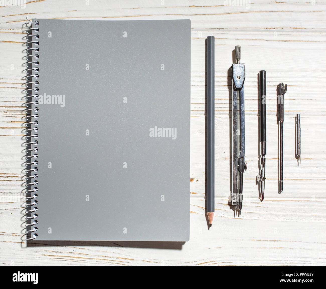 Notebook grigio accanto a strumenti di disegno Foto Stock