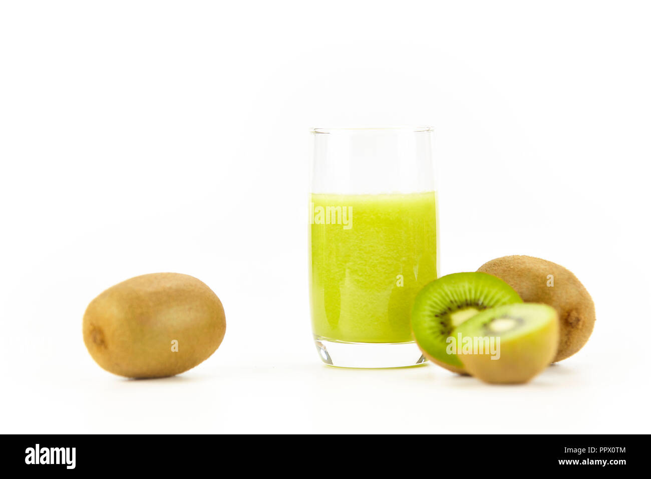 Tre kiwi, uno tagliato a metà e un bicchiere di succo di kiwi isolati su sfondo bianco. Foto Stock