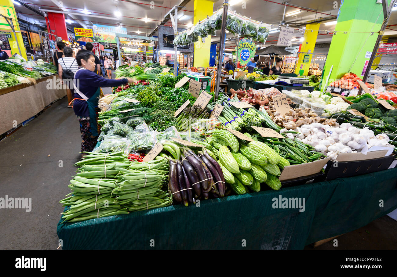 Un titolare di stallo cinese dispone di verdura verde presso la popolare di Rusty sul mercato Sheridan Street, Cairns, estremo Nord Queensland, Australia Foto Stock