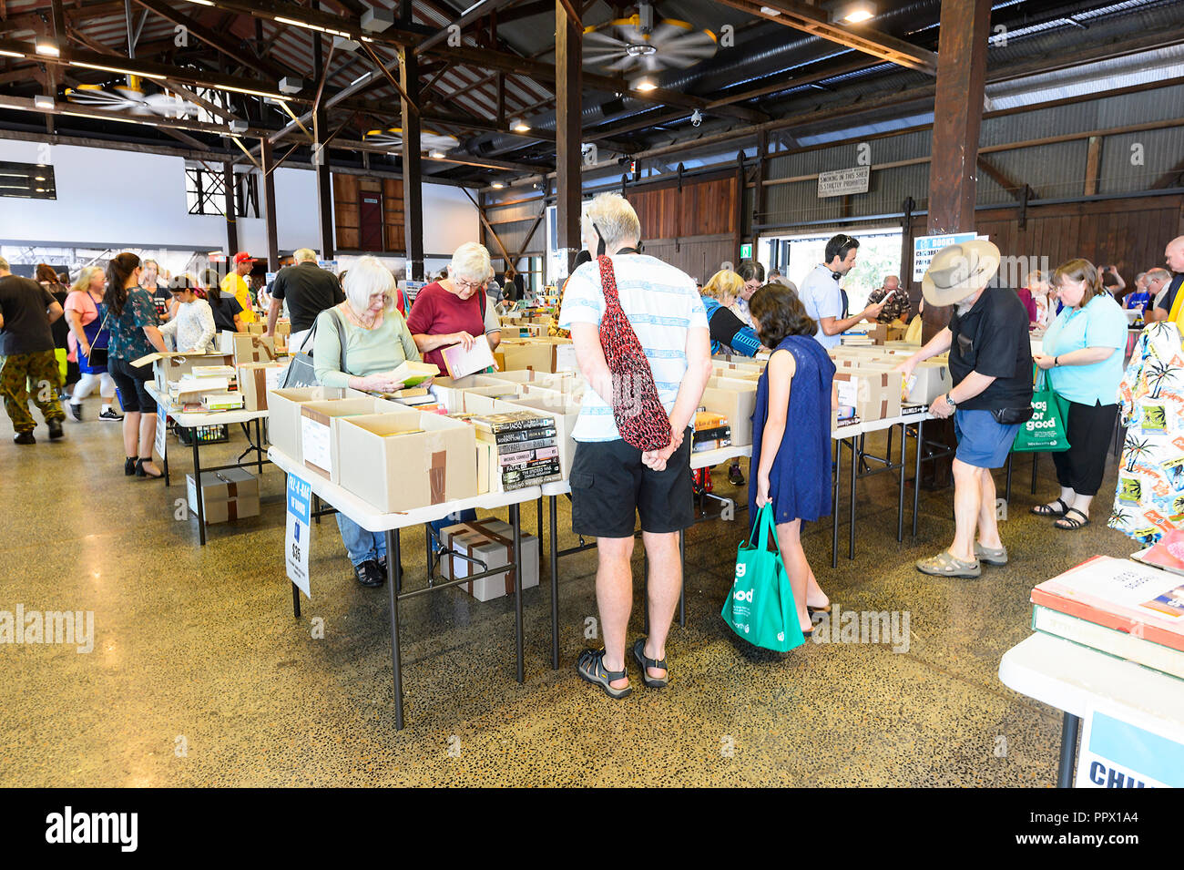 Ai clienti di navigare attraverso le scatole a Vinnies Book Fair, Cairns, estremo Nord Queensland, FNQ, QLD, Australia Foto Stock