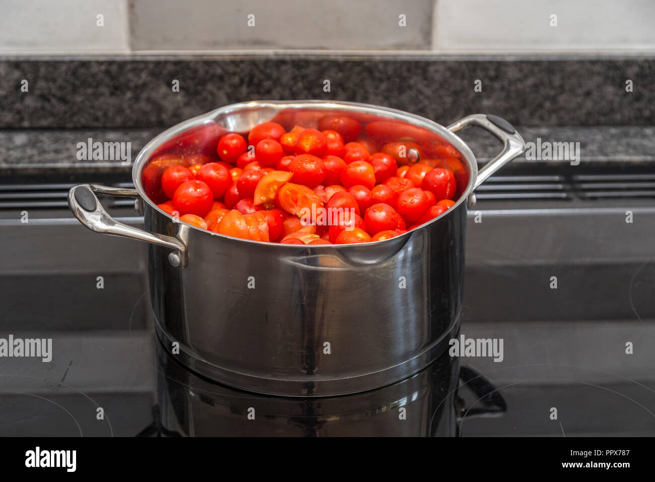 Una grande pentola piena di pomodori su un piano di cottura ad induzione  pronto per rendere la zuppa di pomodoro Foto stock - Alamy