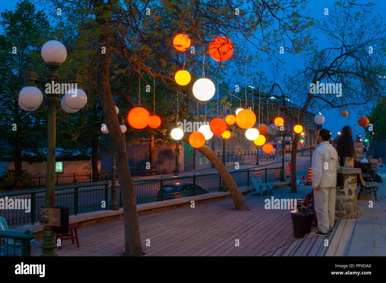 Impianto di illuminazione in un piccolo parco nel Quartier Petit-Champlain quartiere al tramonto, con lanterne pendenti da alberi. Quebec City, in Canada Foto Stock