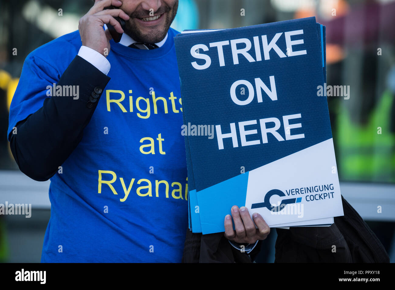 28 settembre 2018, Assia, Frankfurt principale: una compagnia aerea low-cost cavalletti pilota con sciopero poster a una protesta rally al terminale 2 del Rhein-Main Aeroporto. I sindacati in diversi paesi europei hanno chiamato per gli scioperi a basso costo compagnia aerea Ryanair. In Germania, i piloti del Cockpit Association (VC) e gli assistenti di volo organizzato a Verdi partecipare. Foto: Andreas Arnold/dpa Foto Stock