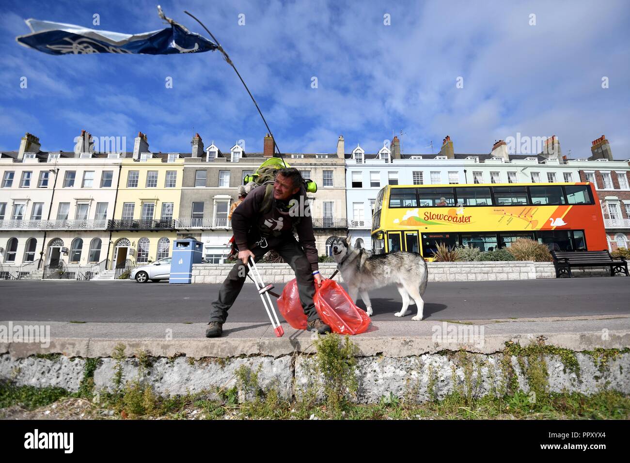 Wayne Dixon, 47, a metà strada attraverso il suo viaggio per la raccolta di rifiuti lungo tutta la costa della Gran Bretagna. Attualmente in Weymouth e è la raccolta di fondi per beneficenza la mente e il nord del cane Inuit società. Egli sta completando la sua sfida con il suo cane Koda, una Northern Inuit, e dice che è "adempiere il sogno di una vita a piedi la costa della Gran Bretagna." "Io sono il prelievo di figliata su tutta la costa della Gran Bretagna. Io scelgo su ogni pezzo di lettiera io cammino passato. Credito: Finnbarr Webster/Alamy Live News Foto Stock