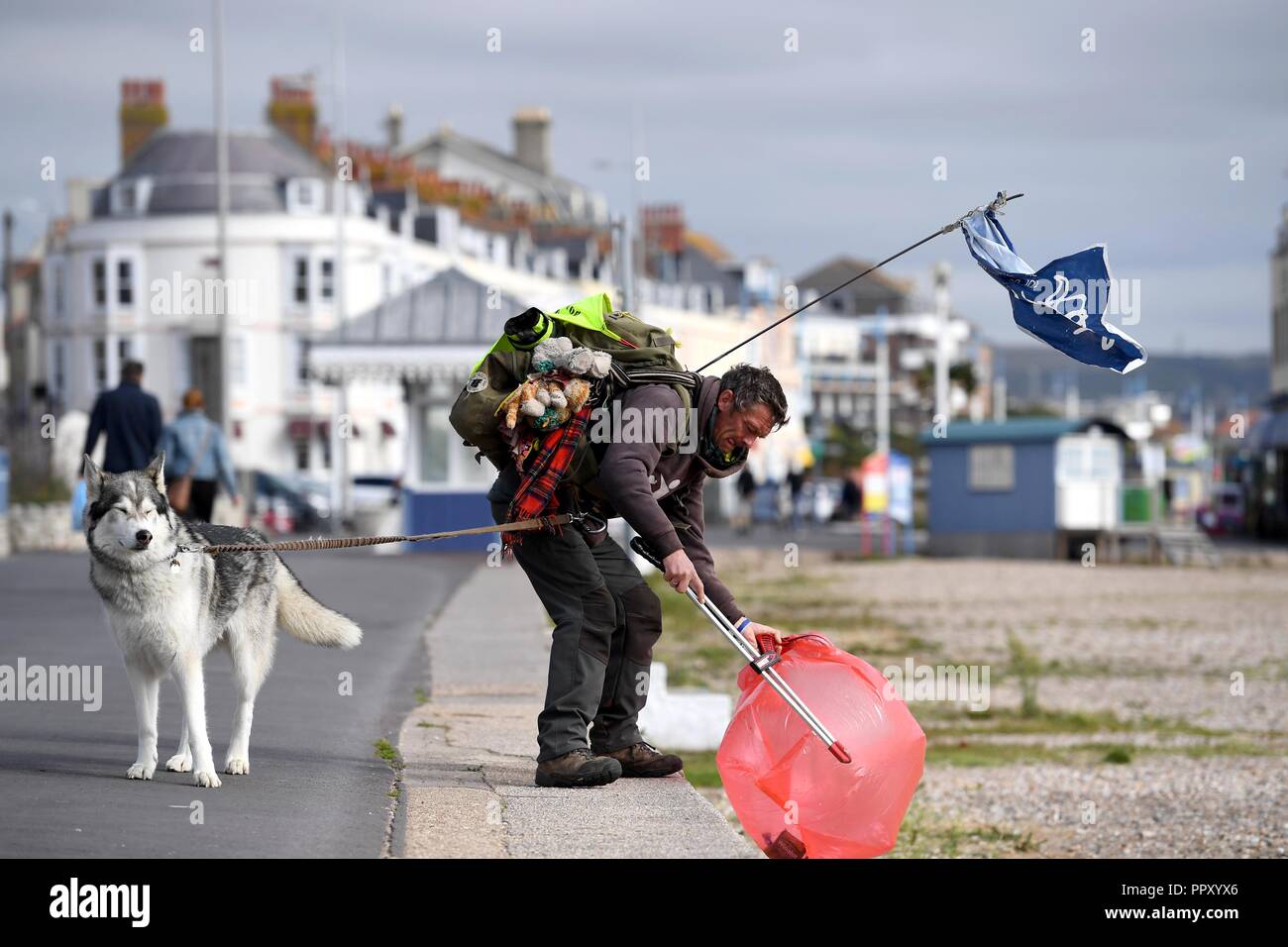 Wayne Dixon, 47, a metà strada attraverso il suo viaggio per la raccolta di rifiuti lungo tutta la costa della Gran Bretagna. Attualmente in Weymouth e è la raccolta di fondi per beneficenza la mente e il nord del cane Inuit società. Egli sta completando la sua sfida con il suo cane Koda, una Northern Inuit, e dice che è "adempiere il sogno di una vita a piedi la costa della Gran Bretagna." "Io sono il prelievo di figliata su tutta la costa della Gran Bretagna. Io scelgo su ogni pezzo di lettiera io cammino passato. Credito: Finnbarr Webster/Alamy Live News Foto Stock