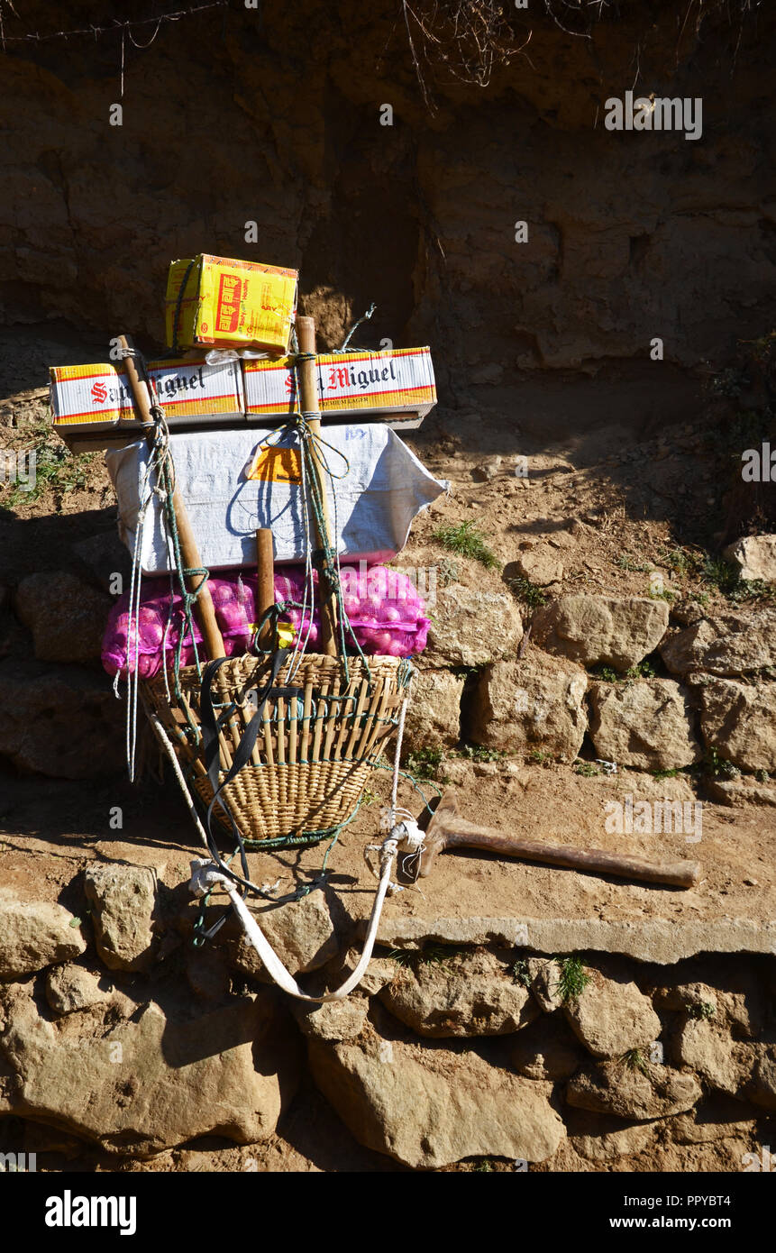 Il Porter's carico a sinistra accanto a un brano a piedi mentre il portiere si appoggia, Solukhumbu, Nepal Foto Stock