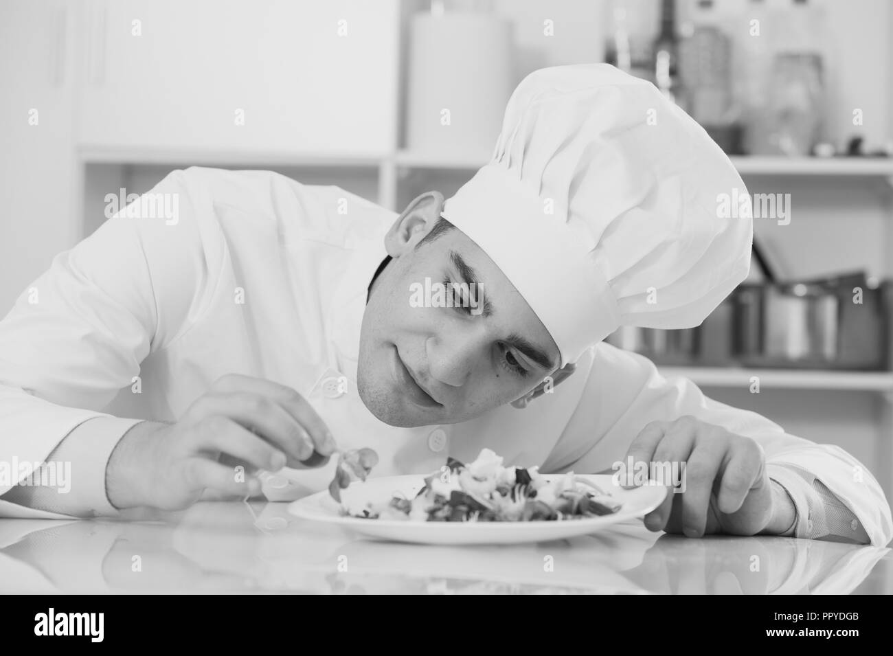 Lo chef è insalata degustating sulla cucina. Foto Stock