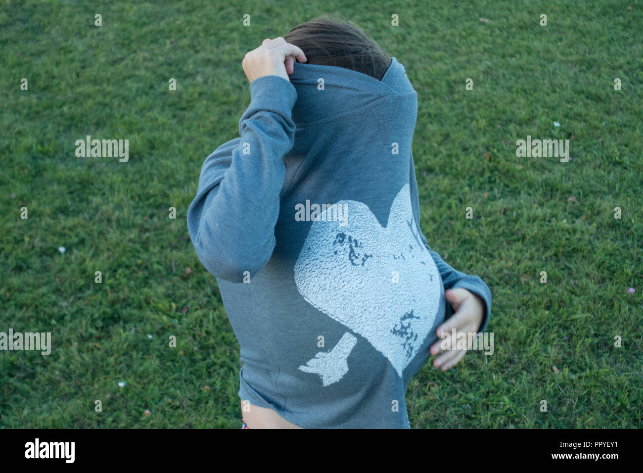 Una ragazza con una faccia nascosta e palla nascosta Foto Stock