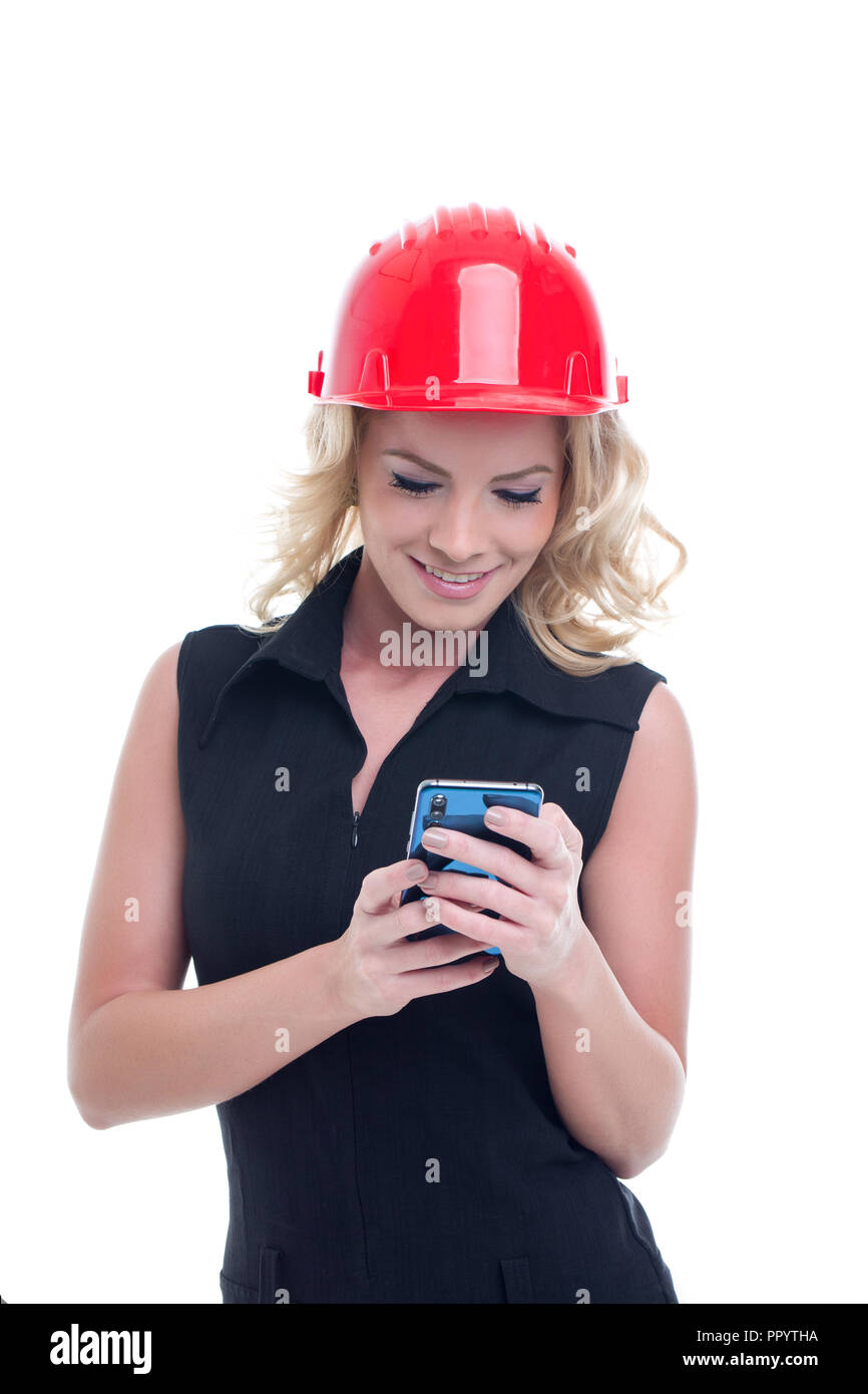 Giovane ingegnere woman in red casco messaging sullo smartphone isolato su bianco Foto Stock