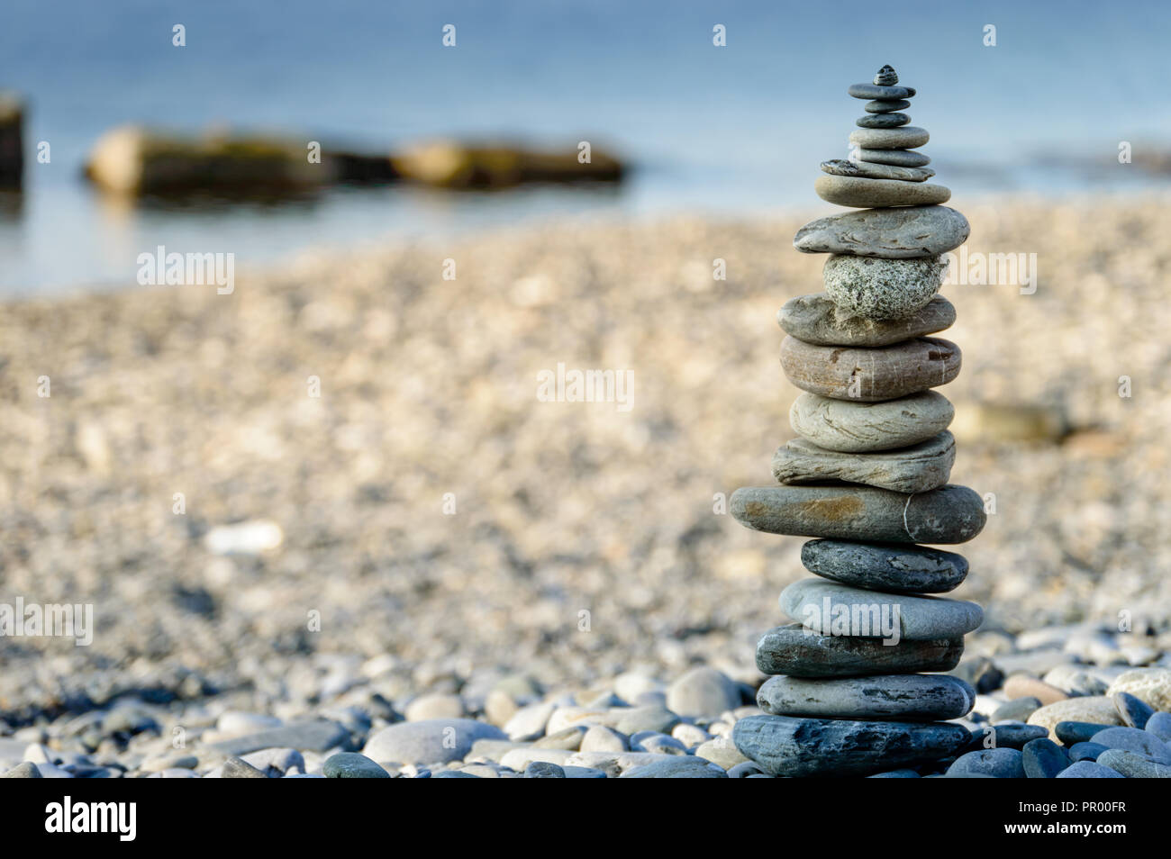 Piramide di pietre di mare sui ciottoli della riva del mare. Il concetto di equilibrio e di spiritualità. Foto Stock