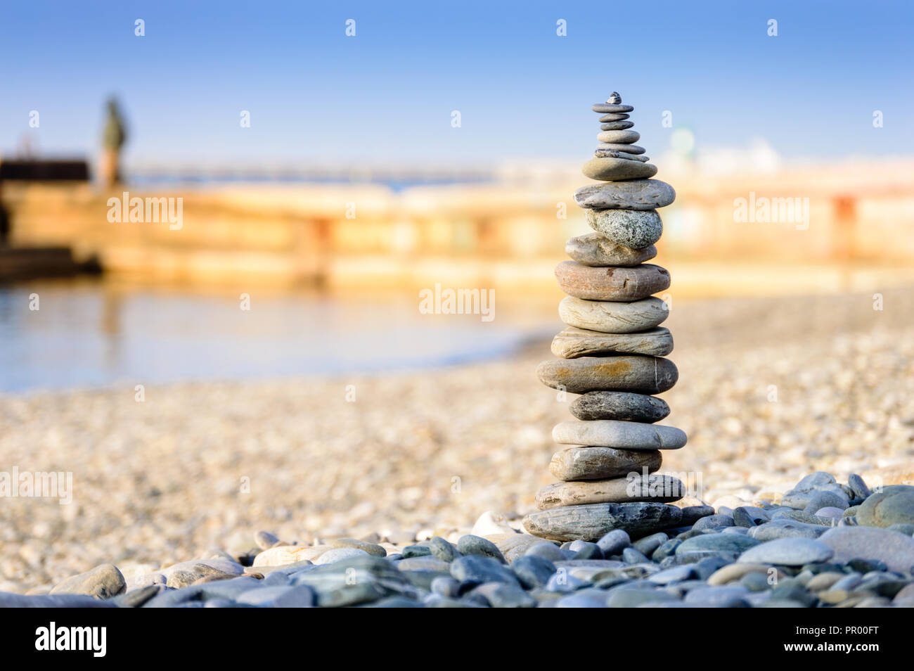 Piramide di pietre di mare sui ciottoli della riva del mare. Il concetto di equilibrio e di spiritualità. Foto Stock