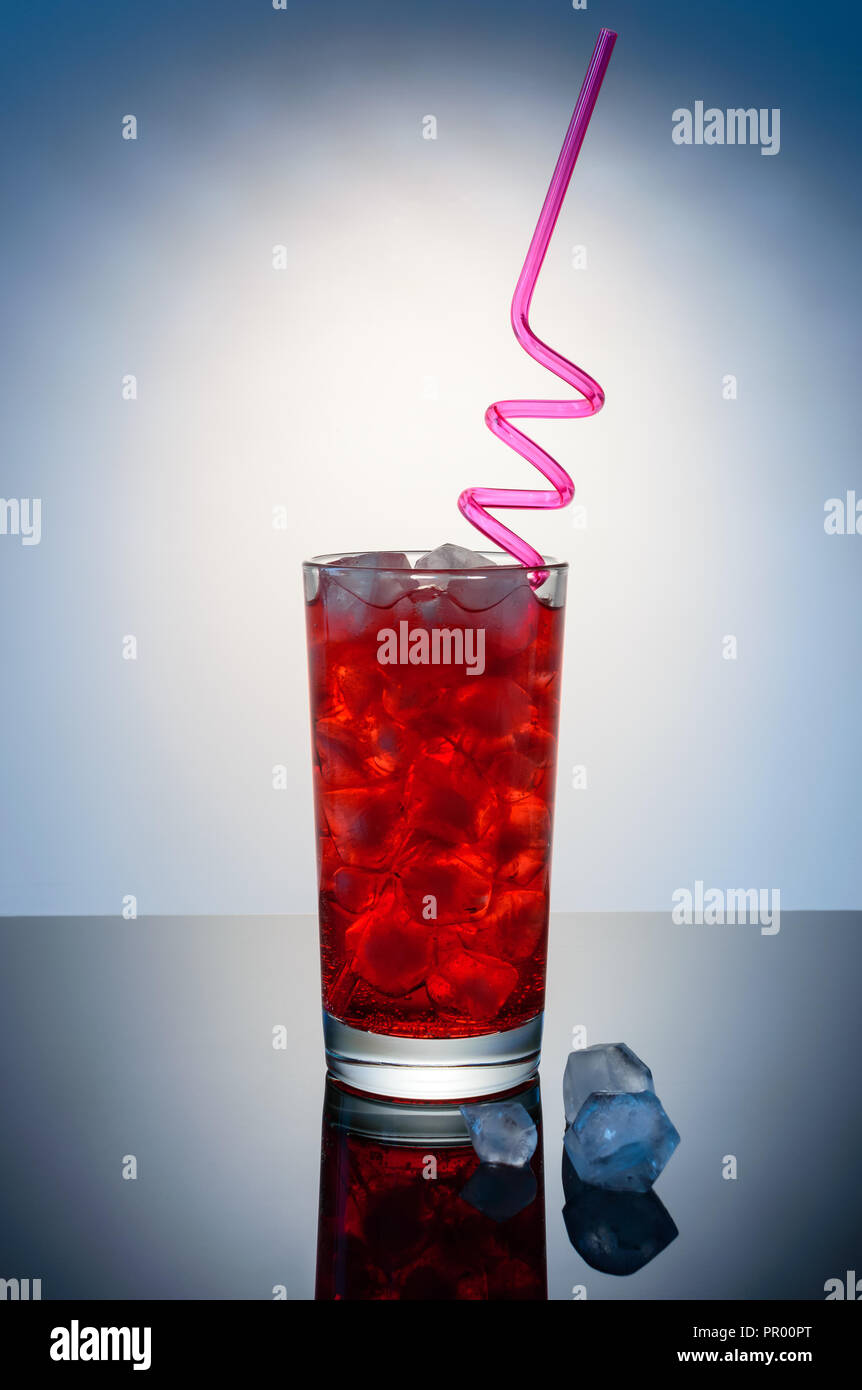 Red drink in vetro con paglia di rosso e i cubetti di ghiaccio Foto Stock