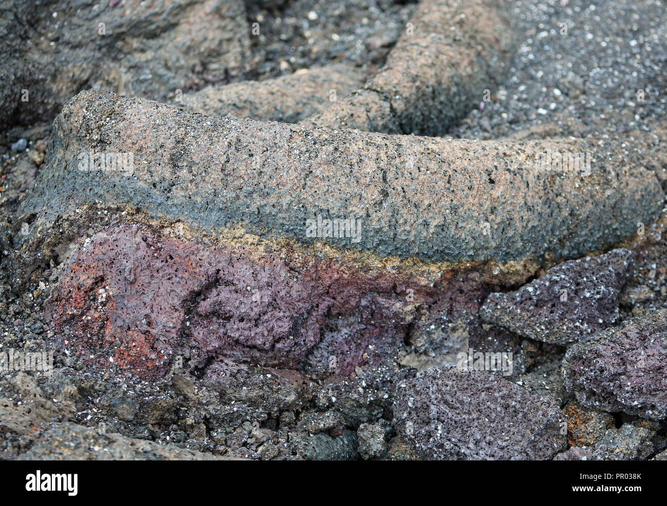 Lava ropy con strati colorati di porpora, giallo, blu-verde e marrone Foto Stock