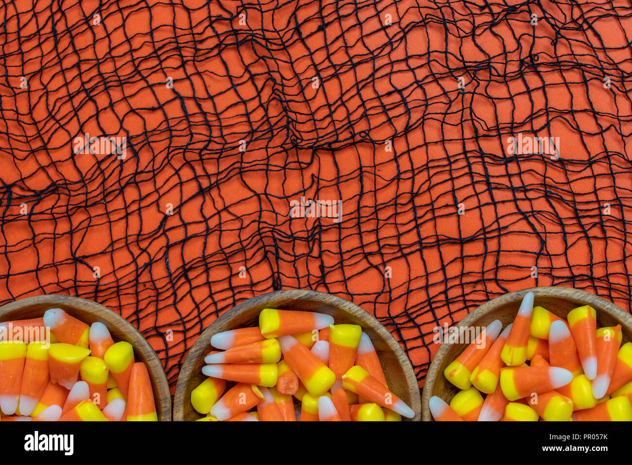 Cereali caramellati confine con webby tessuto nero su uno sfondo arancione Foto Stock