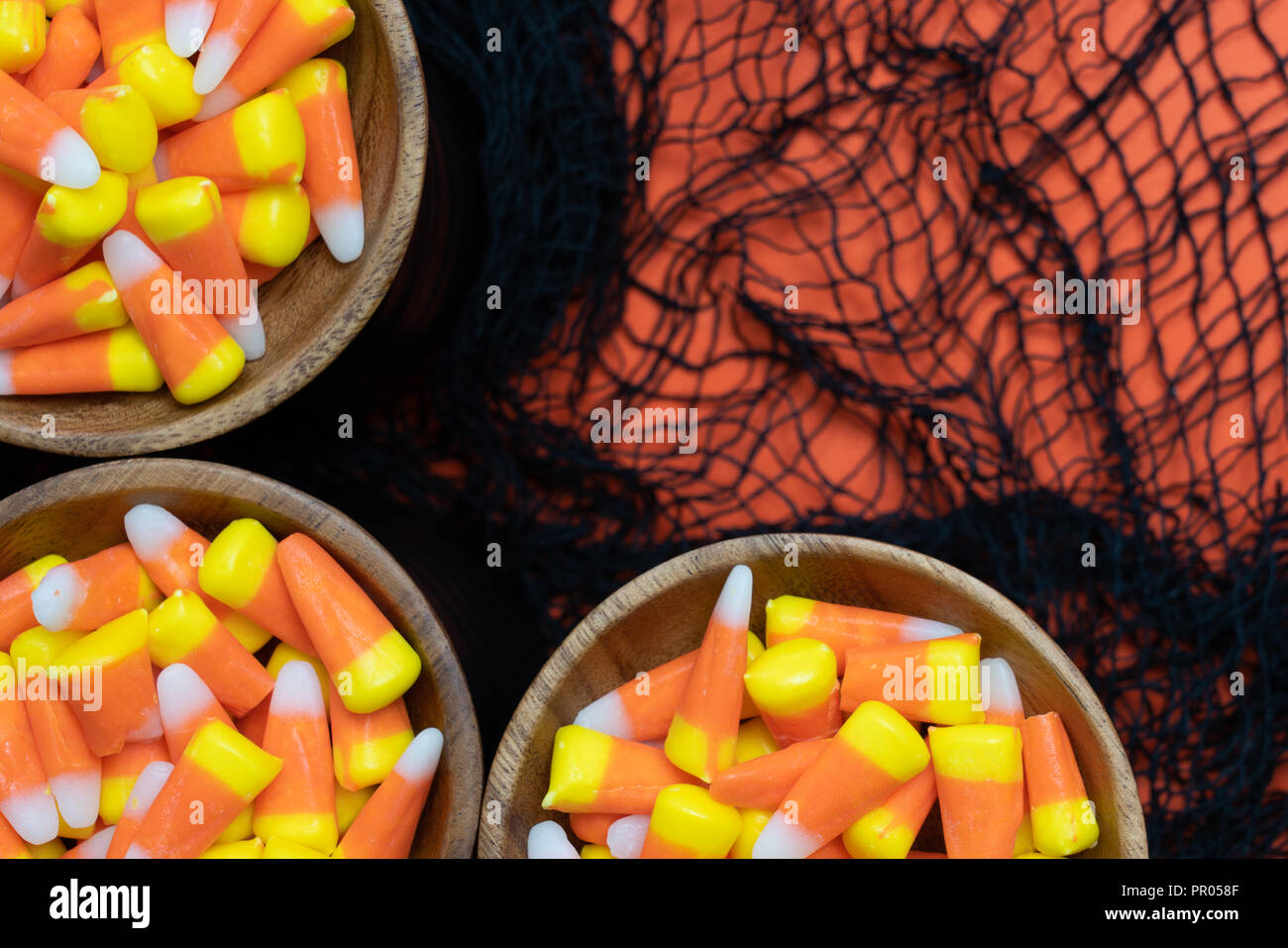 Candy angolo di mais con bordo nero webby tessuto su sfondo arancione Foto Stock