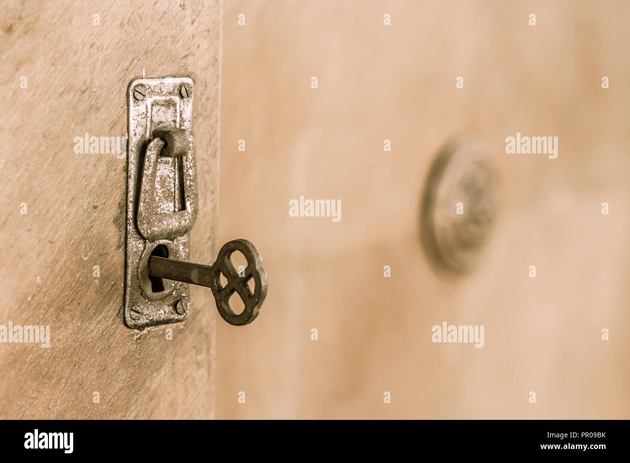 Chiudere la vecchia porta con la vecchia serratura e chiave. Vecchia chiave arrugginita all'interno di una toppa di chiave. Messa a fuoco selettiva su chiave Foto Stock